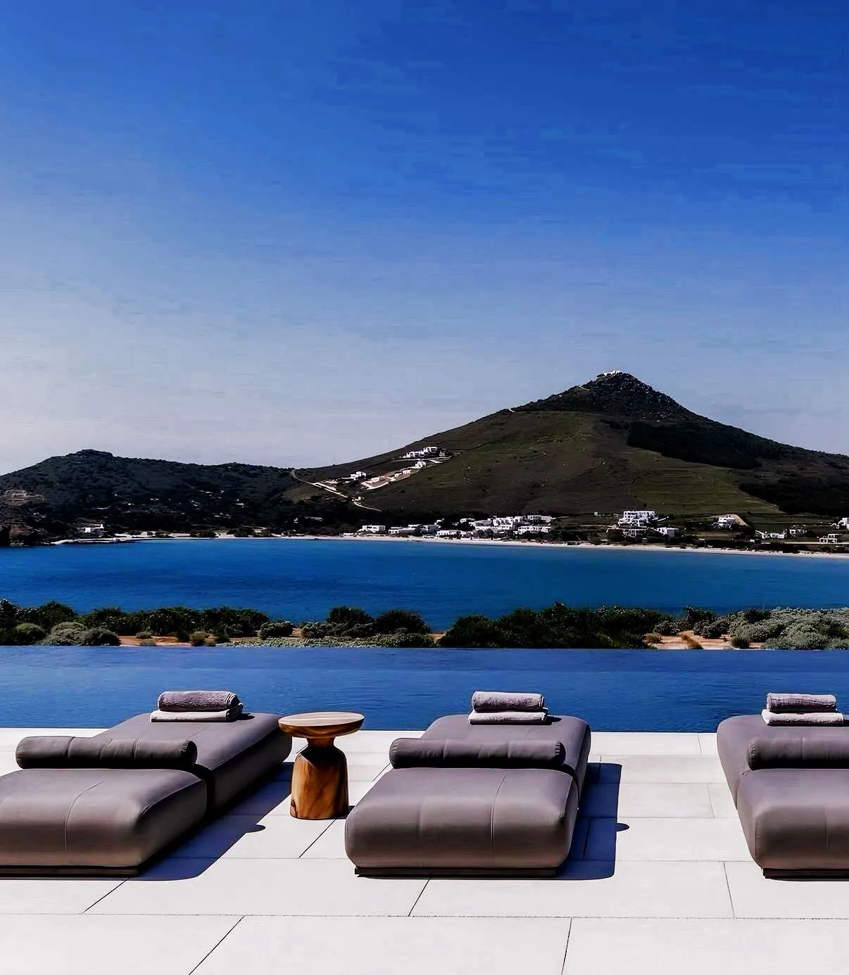 seaside terrace with private loungers and mountain horizon at dusk